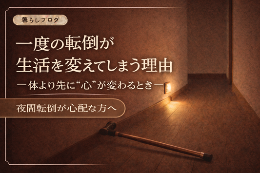 夜の静かな廊下に足元灯が優しく灯り、床に長い杖が倒れている様子。一度の転倒が生活を変えてしまう心理的影響を表現したブログサムネイル。